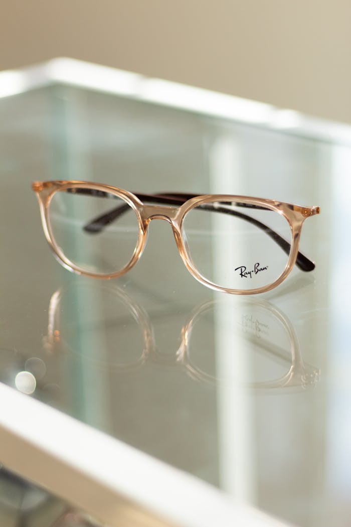 Stylish eyeglasses with transparent frames elegantly placed on a display table.