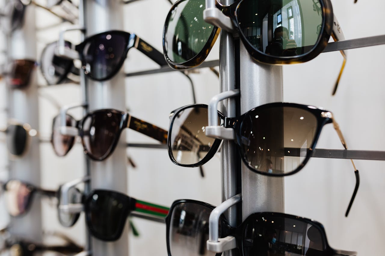 programs-04 Close-up view of stylish sunglasses displayed on a rack in a retail store.